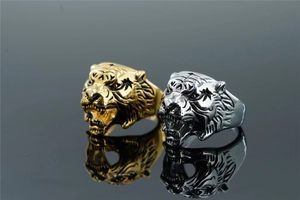 Detailed close-up of tiger head rings in gold and silver finish with realistic carving