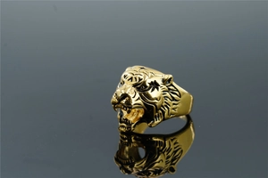 Detailed close-up of a golden tiger head ring with intricate textures and mirror reflection