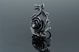 Detailed view of a vintage rose ring with a center zircon and intricate petal carvings