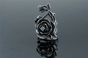 Close-up of vintage oxidized silver rose ring featuring a sparkling central zircon stone