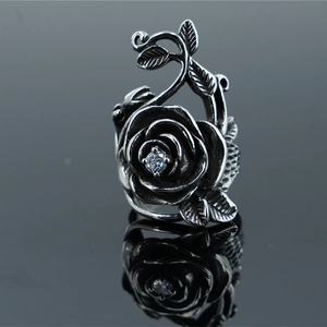 Vintage stainless steel rose ring with central zircon and vine details on a dark base