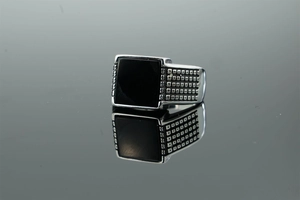Macro shot of men's stainless steel ring featuring square black agate and textured band