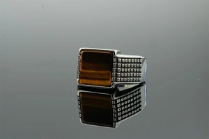 Detailed macro view of vintage silver ring featuring a square tiger eye stone with carvings