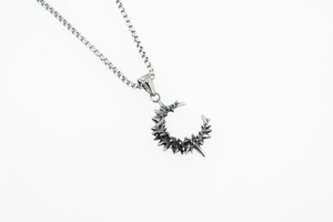 Detailed view of punk style moon pendant necklace with thorn texture on steel box chain
