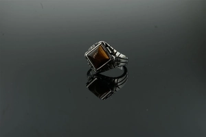 Close-up of vintage stainless steel men's signet ring featuring a polished tiger eye stone