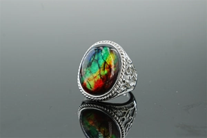 Macro shot of vintage silver ring with oval colorful stone and intricate hollow patterns