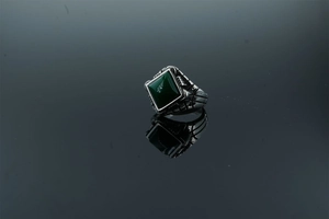 Detailed view of men's vintage steel ring with square green stone and antique relief