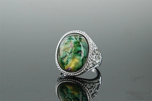 Macro detail of oval abalone shell stone inlay on vintage silver carved steel ring
