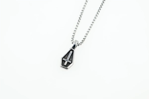Vue macro d'un pendentif cercueil gothique en argent avec détail de croix inversée