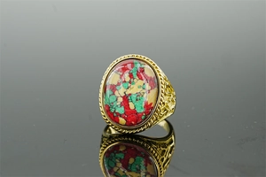 Detail of vintage gold ring with colorful turquoise stone and embossed metal carvings