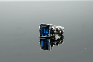 Dettaglio macro di pietra blu rettangolare incastonata in anello vintage stile catena