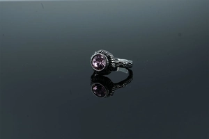 Detail shot of vintage silver-tone ring with purple stone inlay and ornate carvings