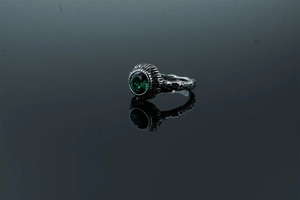 Detailed view of vintage oxidized silver ring with textured bark finish and green gemstone