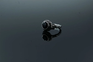 Macro detail of vintage branch texture ring featuring a round black gemstone and silver finish