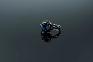 Macro shot of vintage silver ring with blue gemstone and textured bark pattern
