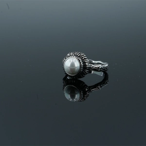 Vintage style ring featuring a large white pearl and textured silver band with mirror reflection