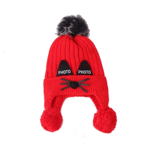 Winter knit baby hat with cartoon cat design, ear flaps and three faux fur pom poms