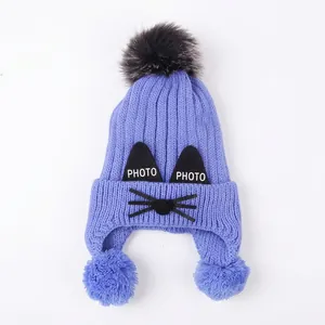 Blue kids knit hat with cat ears and three fluffy pom poms for winter warmth