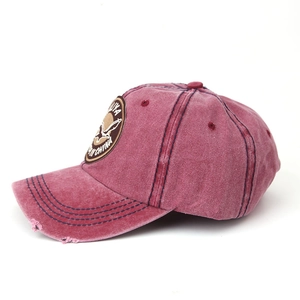 Detailed view of the vintage washed red cotton baseball cap with distressed brim and patch