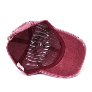 Detail of washed cotton baseball cap with distressed frayed edges and metal buckle strap