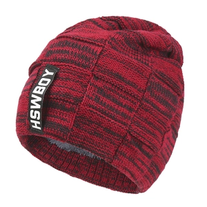 Detail of red and black knit beanie featuring thick fleece lining and brand label