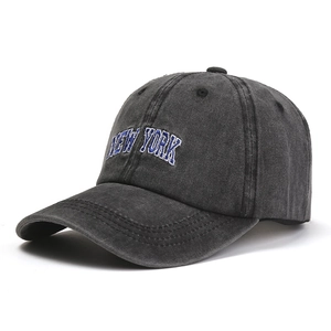 Detail of embroidered New York logo on washed dark grey cotton baseball cap