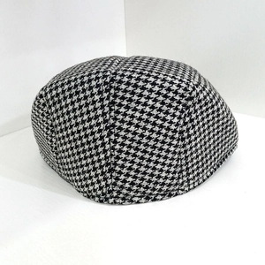 Close-up of the black and white herringbone pattern on a wool flat cap for men