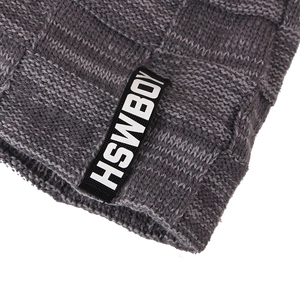 Detail view of grey knit beanie featuring textured square patterns and HSWBOY woven label