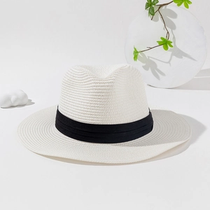 Detail of elegant cream straw hat with double black pleated ribbon and fine weave texture