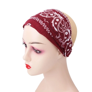 Detail view of burgundy paisley print elastic headband on model for yoga and sports