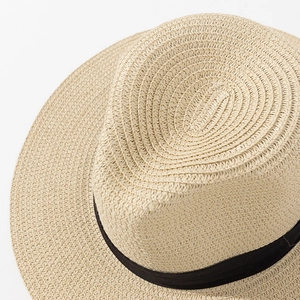 Detail of classic beige straw fedora hat featuring a stylish black ribbon band texture