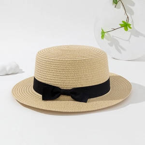 Elegant flat top straw boater hat with black ribbon and bow on a minimalist display