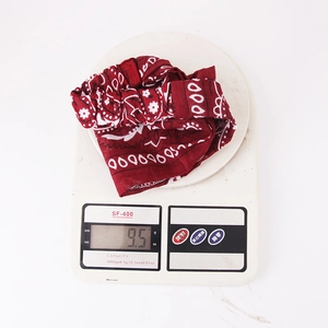 Detailed view showing the red paisley print elastic headband weighing 9.5g on a digital scale