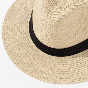 Close-up of natural woven straw texture and black grosgrain ribbon on Panama sun hat