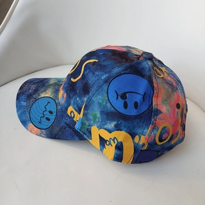 Close-up of vibrant tie-dye patterns and blue smiley face print on a cotton baseball cap