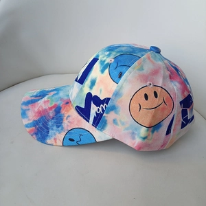 Detail of colorful tie-dye cotton baseball cap featuring smiley face prints and blue graphics
