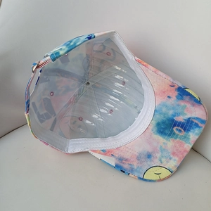 Detail view of the tie-dye cotton baseball cap interior showing the graffiti brim and buckle