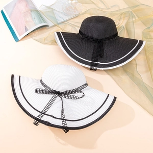 Detailed view of wide brim straw hats with elegant plaid bows and contrasting edges