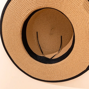 Detail view of woven straw hat interior with adjustable size drawstring and sweatband