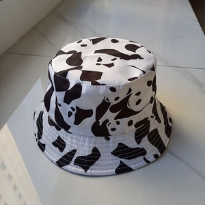 Classic white cotton bucket hat with cute black panda print patterns shown on marble surface