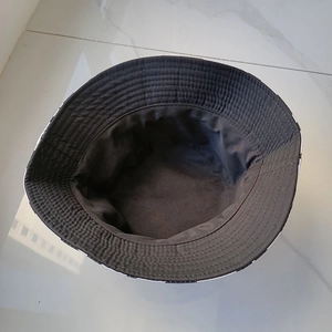 Detail of reinforced stitching on the brim of a reversible black and white plaid bucket hat