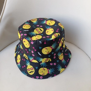 Close-up of black bucket hat with funny cartoon pineapple prints and vibrant colors