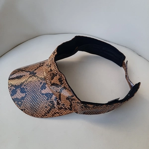 Detailed view of the faux leather python snake print texture on a visor sun hat