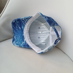 Detail of blue wave tie-dye baseball cap showing interior sweatband and metal buckle
