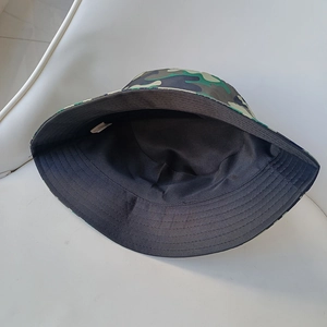 Detailed macro view of camo bucket hat featuring inner black lining and care label detail