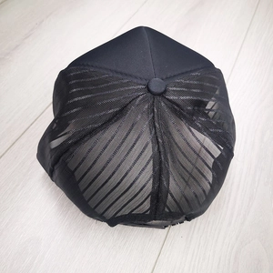 Detail view of the breathable mesh back and solid black panel of this trucker hat