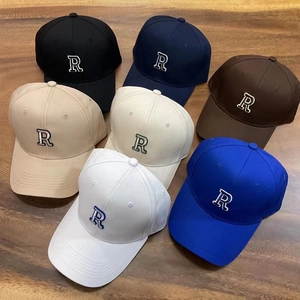 Detailed top view of six cotton baseball caps with 3D letter R embroidery on wooden desk