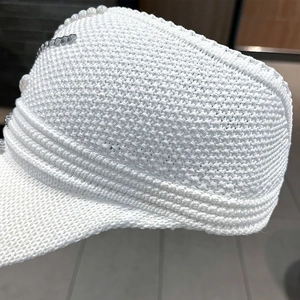 Detail view of white knitted sun hat with pearl decorations and silver metallic accents