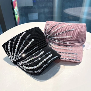 Detail of pink and black knit sun visors with pearl and rhinestone embellishments