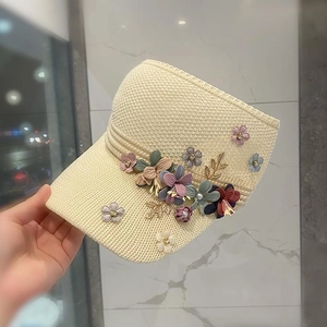 Beige knit sun visor hat for women featuring colorful 3D fabric flowers and golden charms